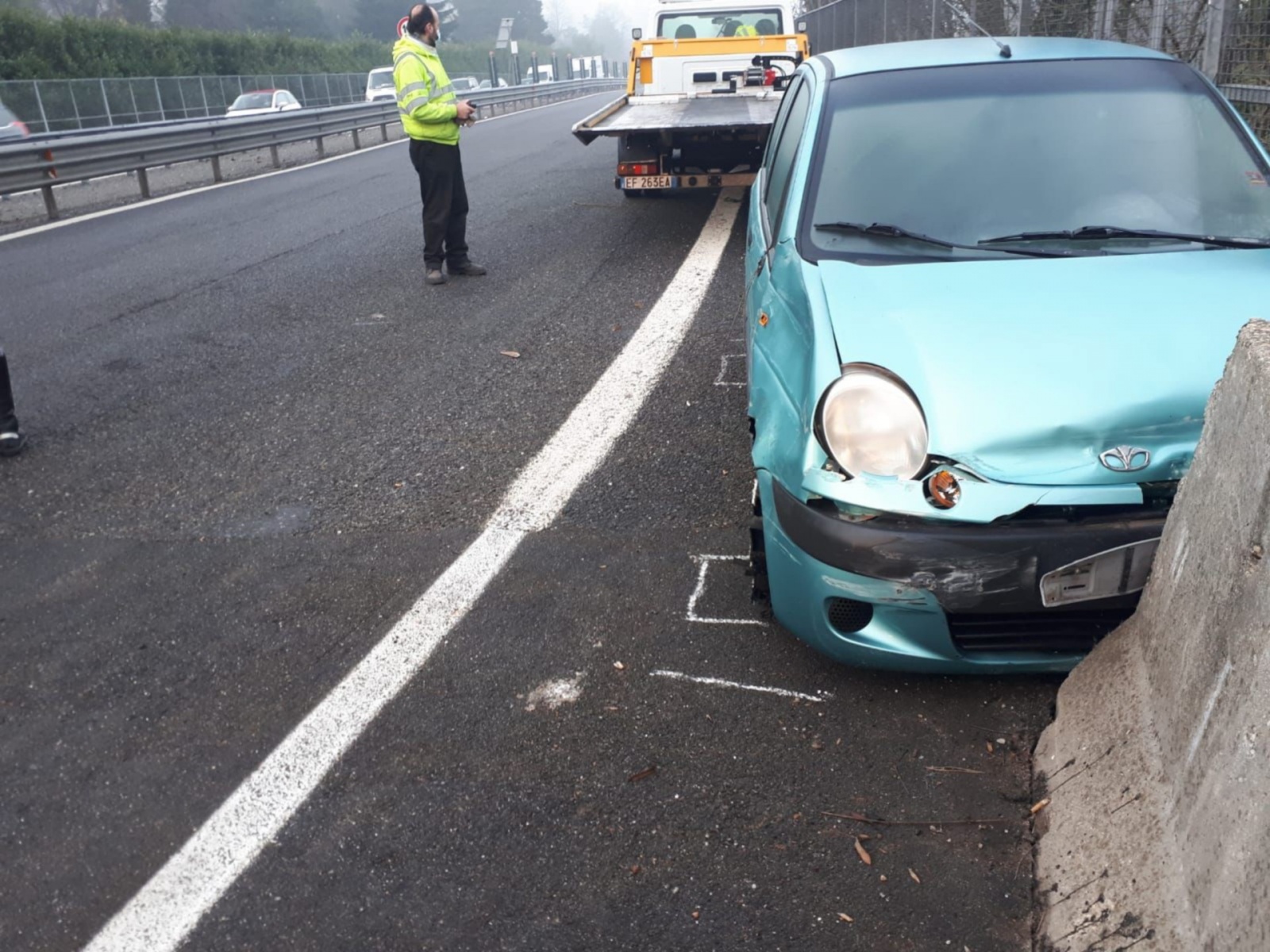 L'uomo in giubbotto catarifrangente effettua una telefonata dopo un  incidente stradale